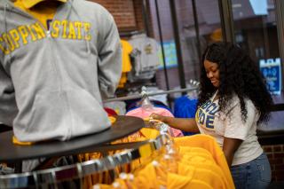 A female student shops for clothing in the Coppin campus bookstore